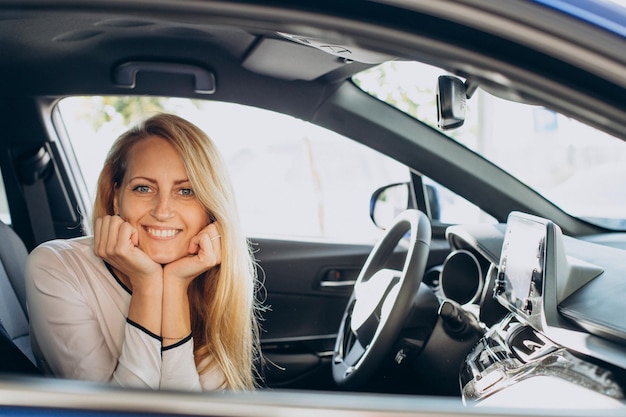 Mujer eligiendo un coche en una sala de exposición de coches