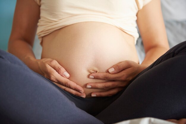 Mujer embarazada acaricia su abdomen