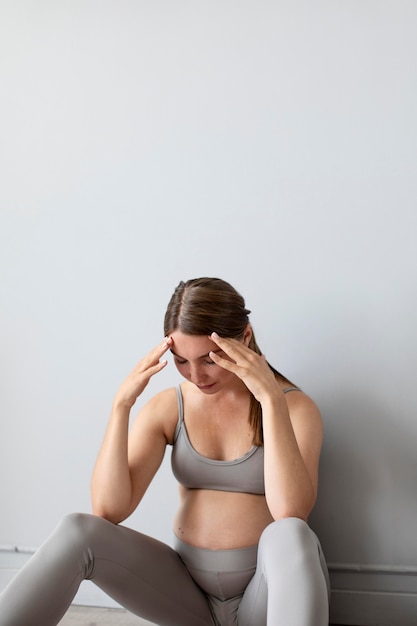 Mujer embarazada con aspecto cansado después de hacer ejercicio con espacio de copia