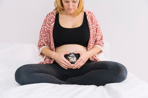 Foto gratuita mujer embarazada en cama con ultrasonido