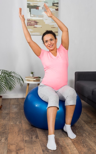 Mujer embarazada, en casa, con, pelota