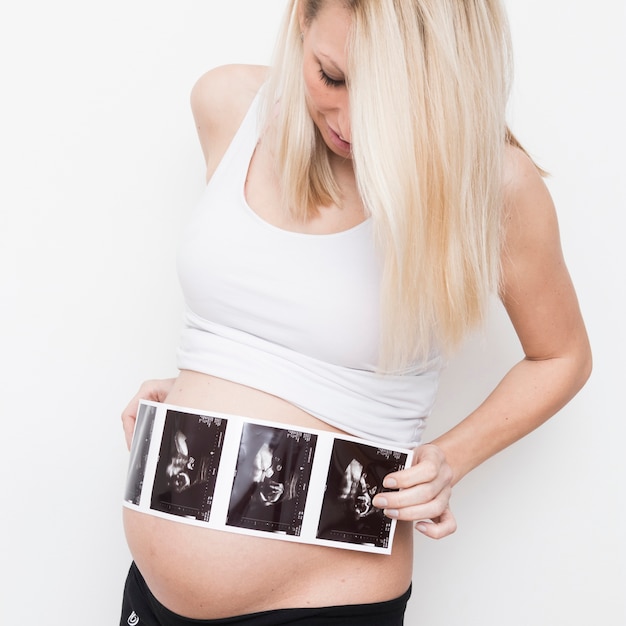 Foto gratuita mujer embarazada colocando rayos x en barriga