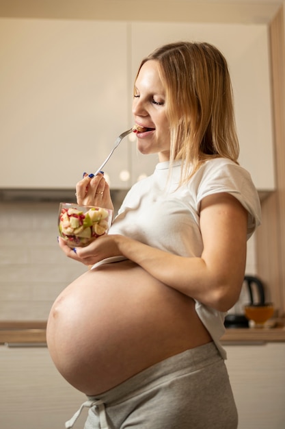 Mujer embarazada comiendo ensalada deliciosa