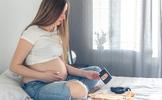 Foto gratuita una mujer embarazada con una ecografía del concepto de embarazo infantil