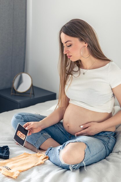 Foto gratuita una mujer embarazada con una ecografía del concepto de embarazo infantil