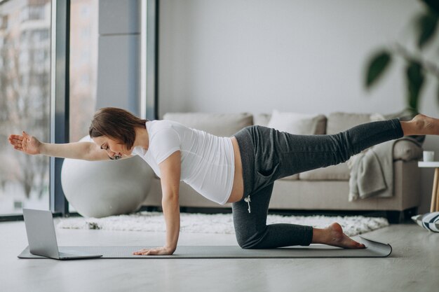Mujer embarazada ejercicio de yoga en casa