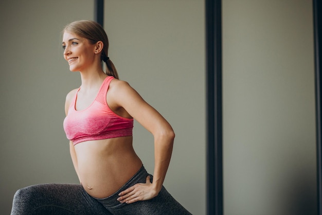 Mujer embarazada ejercitándose en una clase de pilates