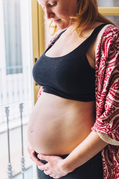 Mujer embarazada enfrente de balcón