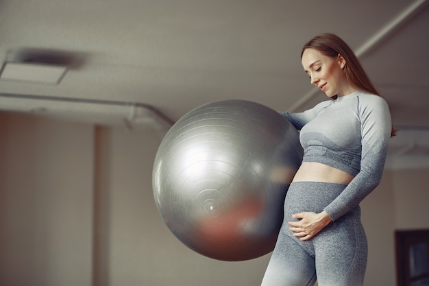 Foto gratuita mujer embarazada entrenando en un gimnasio