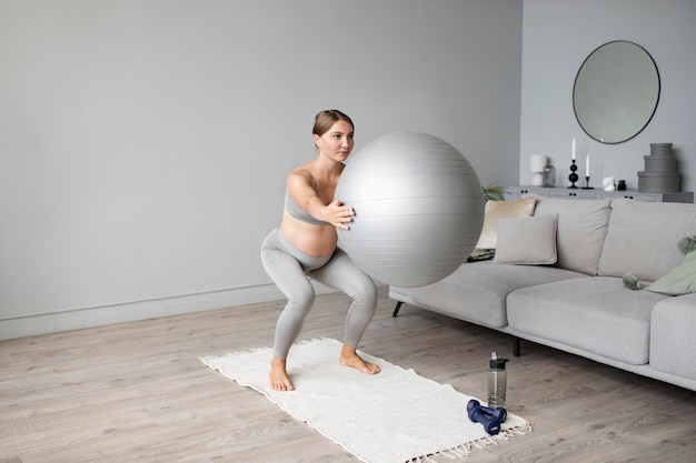 Mujer embarazada haciendo ejercicio en casa