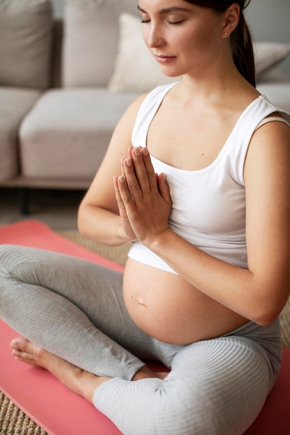 Mujer embarazada haciendo yoga en casa