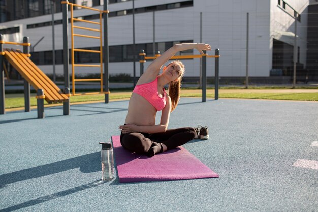 Mujer embarazada haciendo yoga solo al aire libre