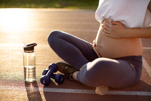 Mujer embarazada haciendo yoga solo al aire libre