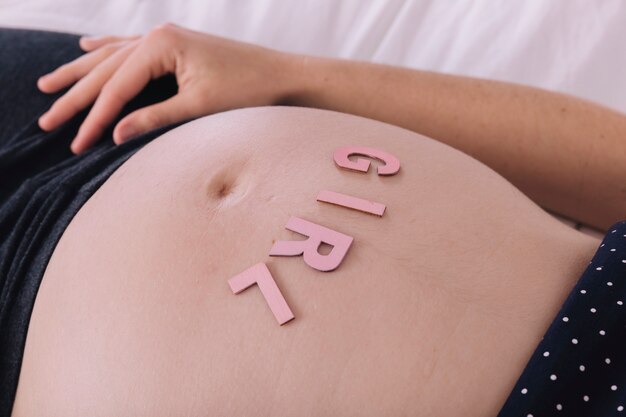Mujer embarazada con letras que ponen girl