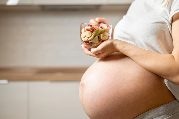 Foto gratuita mujer embarazada manos sosteniendo una deliciosa ensalada