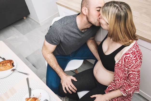 Mujer embarazada y marido en cocina