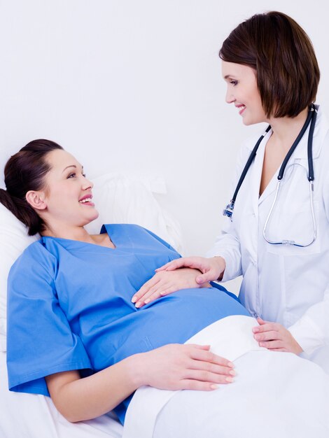 Mujer embarazada con médico en el hospital de maternidad antes del parto