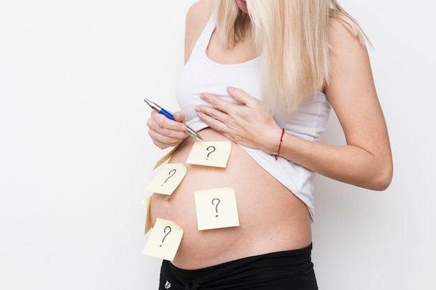 Foto gratuita mujer embarazada con notas adhesivas
