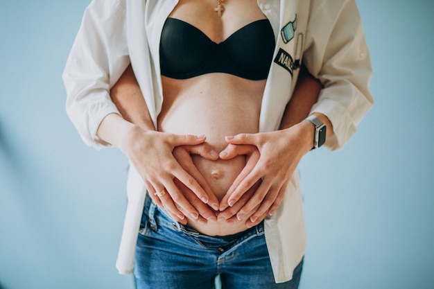 Mujer embarazada, padre y madre sosteniendo el vientre