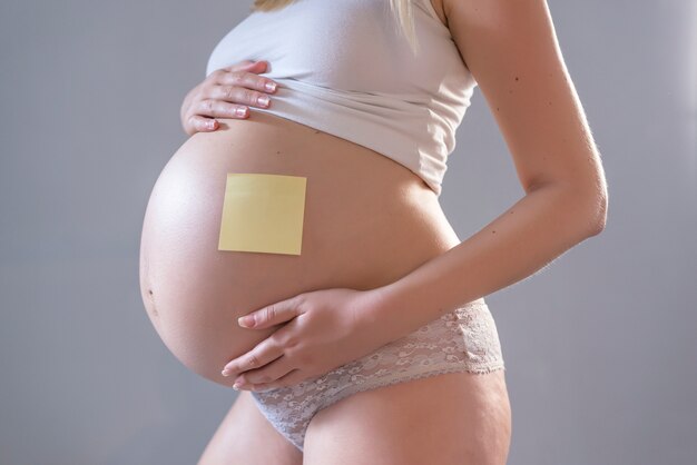 Mujer embarazada con papel de cartas en su vientre