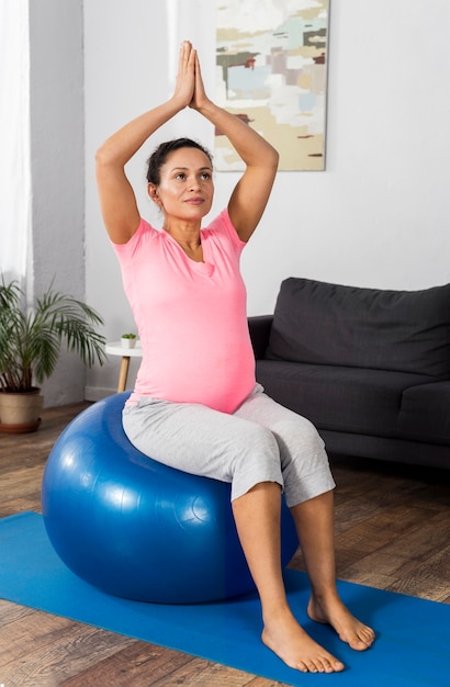 Mujer embarazada con pelota para hacer ejercicio