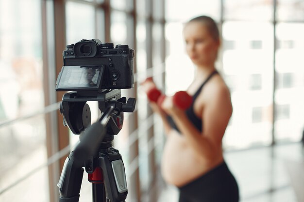Mujer embarazada practica deportes con dambbels
