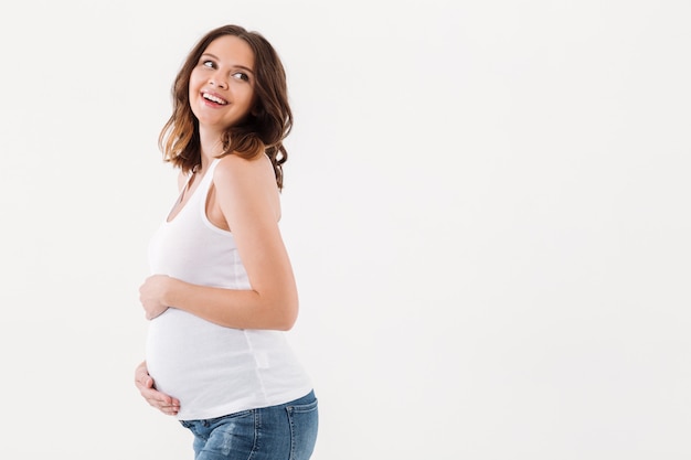 Foto gratuita mujer embarazada que se coloca aislada