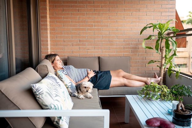 Mujer embarazada que se establecen y relajarse en un sofá