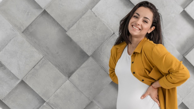 Mujer embarazada sonriente con espacio de copia