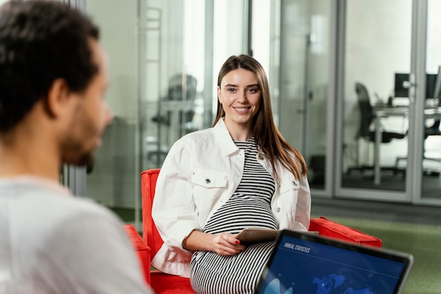 Foto gratuita mujer embarazada tener una reunión con su compañero de trabajo