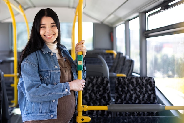 Foto gratuita mujer embarazada de tiro medio en autobús