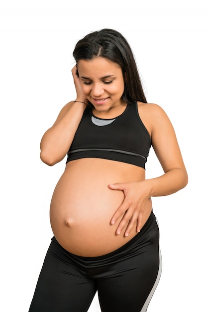 Mujer embarazada tocando su gran barriga.