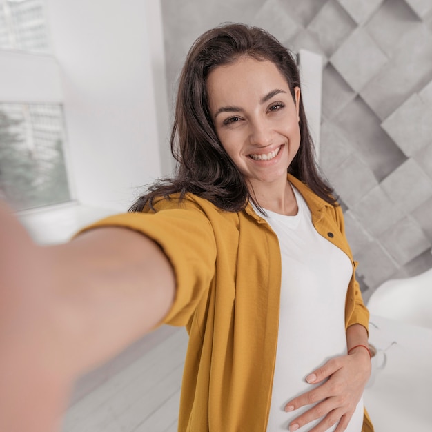 Mujer embarazada tomando un selfie