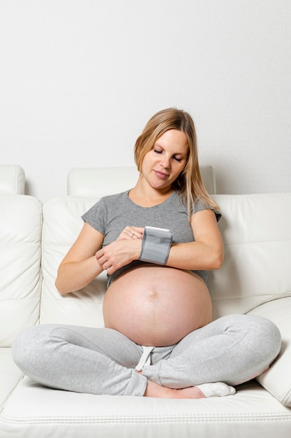 Foto gratuita mujer embarazada usando un dispositivo médico