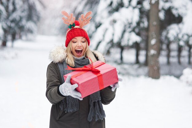 Mujer emocionada con gran regalo de Navidad