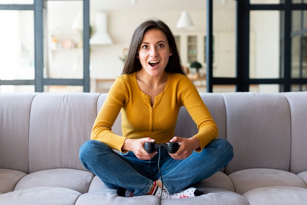 Foto gratuita mujer emocionada jugando videojuegos