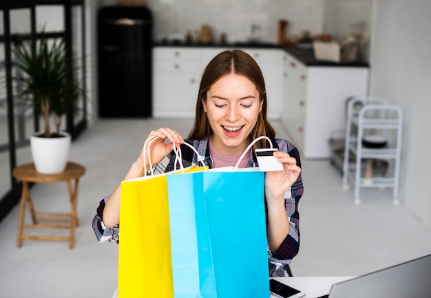 Foto gratuita mujer emocionada mirando dentro de bolsas de vacaciones