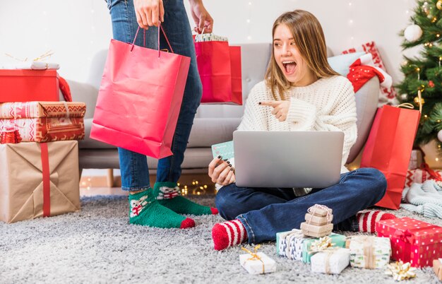 Mujer emocionada que señala en el bolso de compras