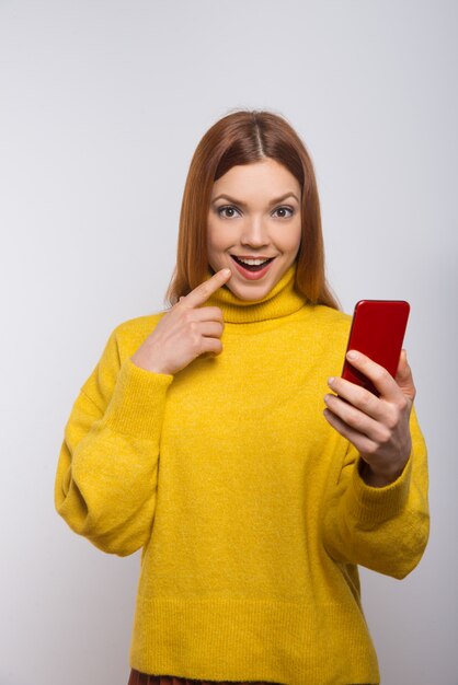 Mujer emocionada con smartphone y mirando