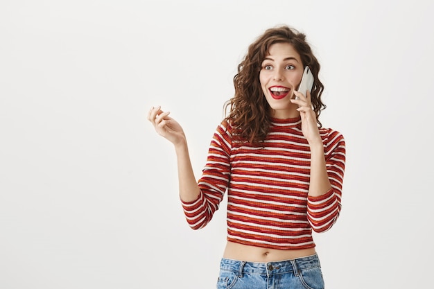 Foto gratuita mujer emocionada sorprendida hablando por teléfono móvil, sonriendo asombrado