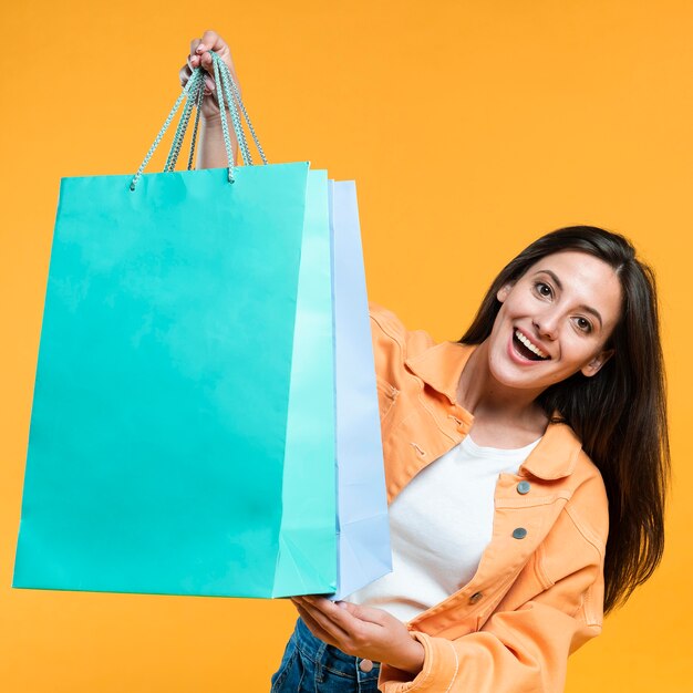 Mujer emocionada sosteniendo un montón de bolsas de la compra.