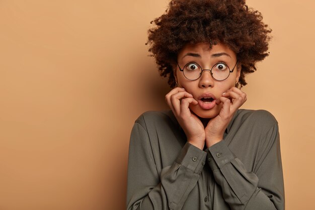 Mujer emocional asustada ha asustado expresión de la cara de alarma, mira con miedo