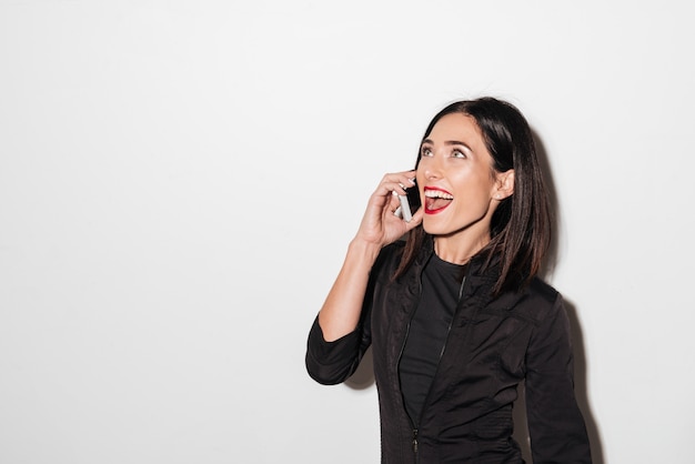 Mujer emocional con labios rojos hablando por teléfono móvil.