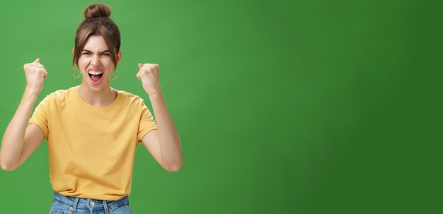 Foto gratuita mujer emotiva guapa furiosa y poderosa en camiseta amarilla con dientes separados gritando de alegría b