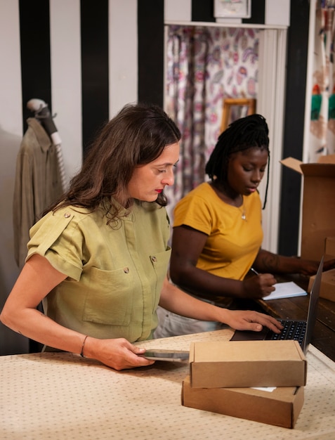 Foto gratuita mujer empacando ropa en una tienda de segunda mano