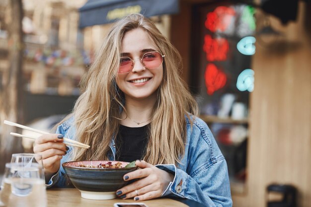 Mujer empresaria complacida con gafas de sol de moda y chaqueta de mezclilla