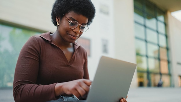 Mujer empresaria trabajando en una laptop al aire libre afroamericana