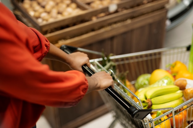 mujer, empujar, carrito de compras, en, el, supermercado