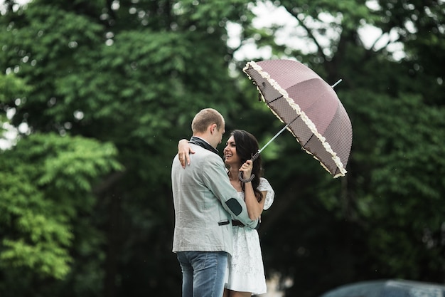 Mujer enamorada con paraguas mirando a su novio