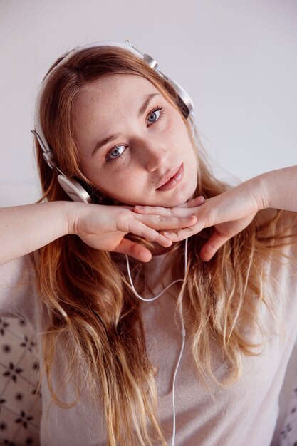 Mujer encantadora en auriculares mirando a la cámara